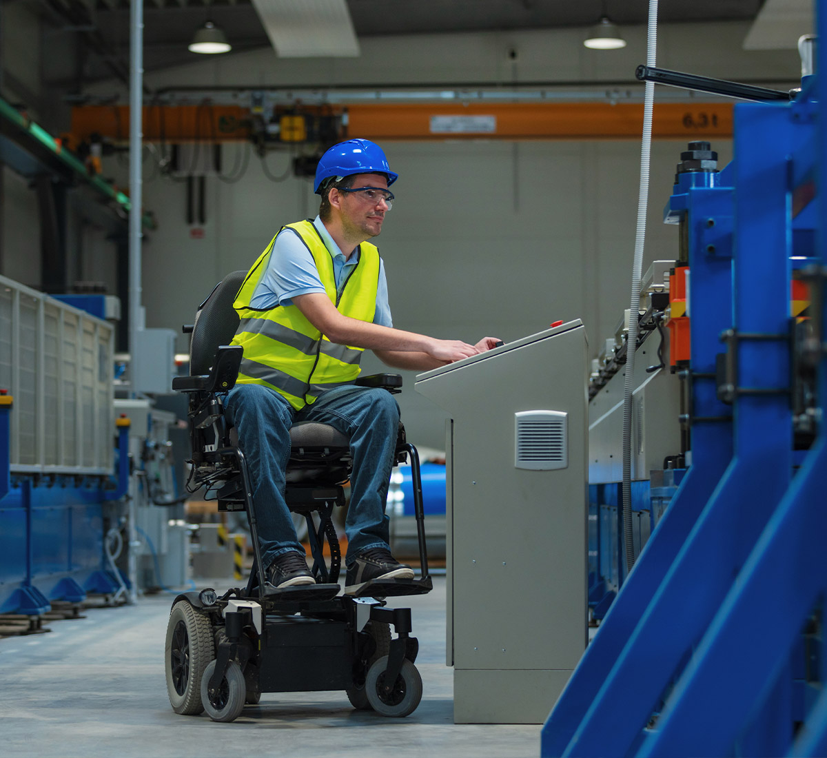 Mitarbeiter im Rollstuhl arbeitet in einem Industriebetrieb