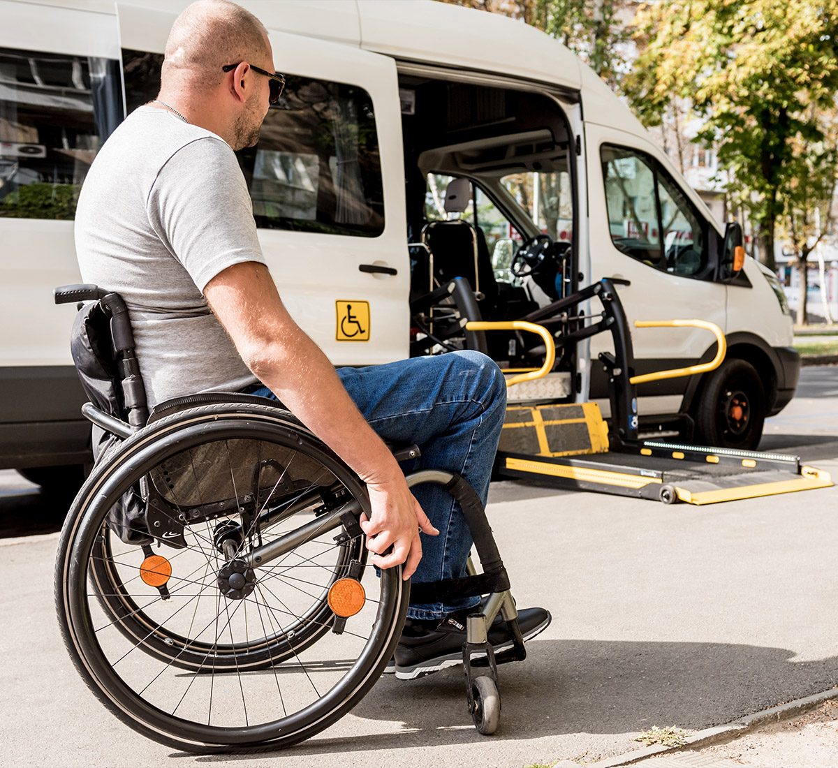Rollstuhlfahrer steigt an einem barrierefreien Kleinbus ein